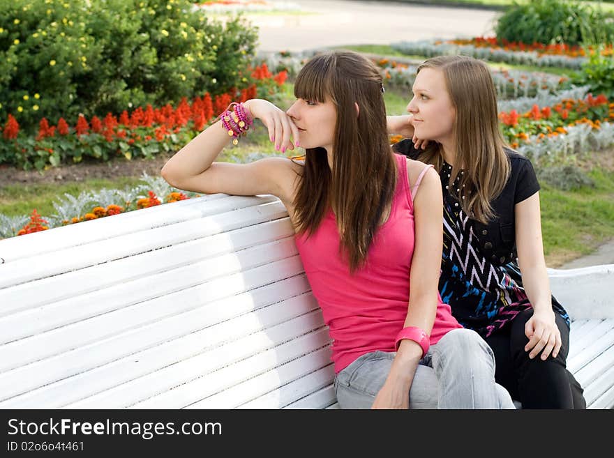 Two female friends sitting on bench