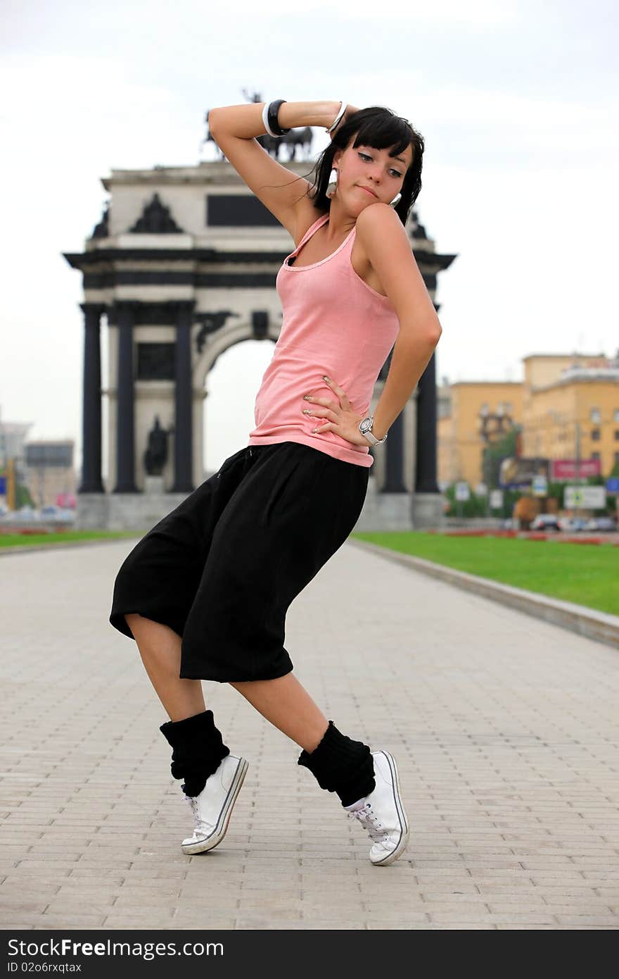 Woman modern ballet dancer in city against classic arch