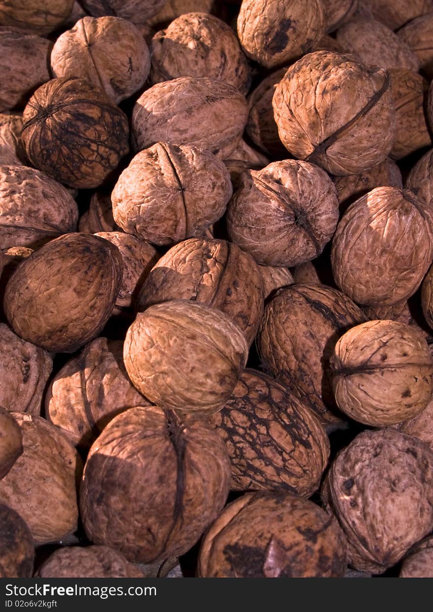 Background close-up heaps of walnuts some of them dirty or old