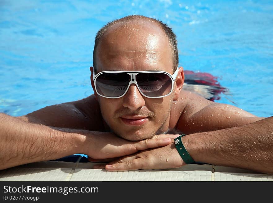 Portrait of a young man on the swimming pool