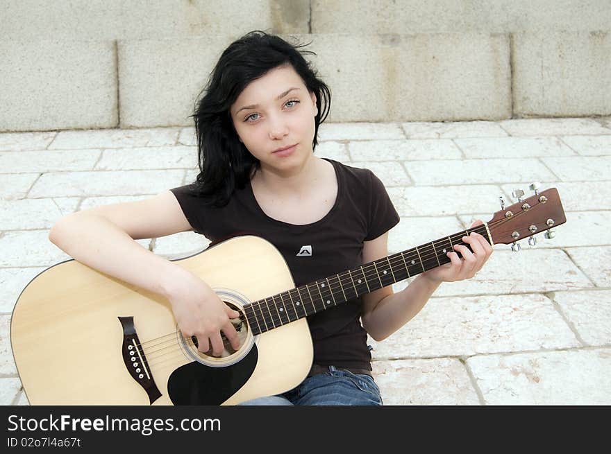 Beautiful Brunette Girl playing guitar