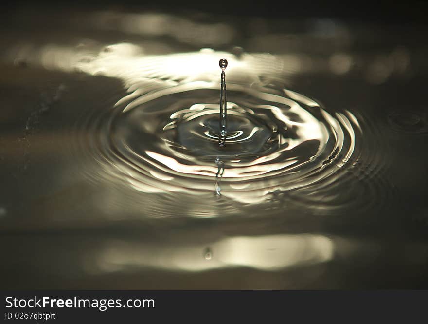 Water drop captured while descending on to the still water surface. Water drop captured while descending on to the still water surface.