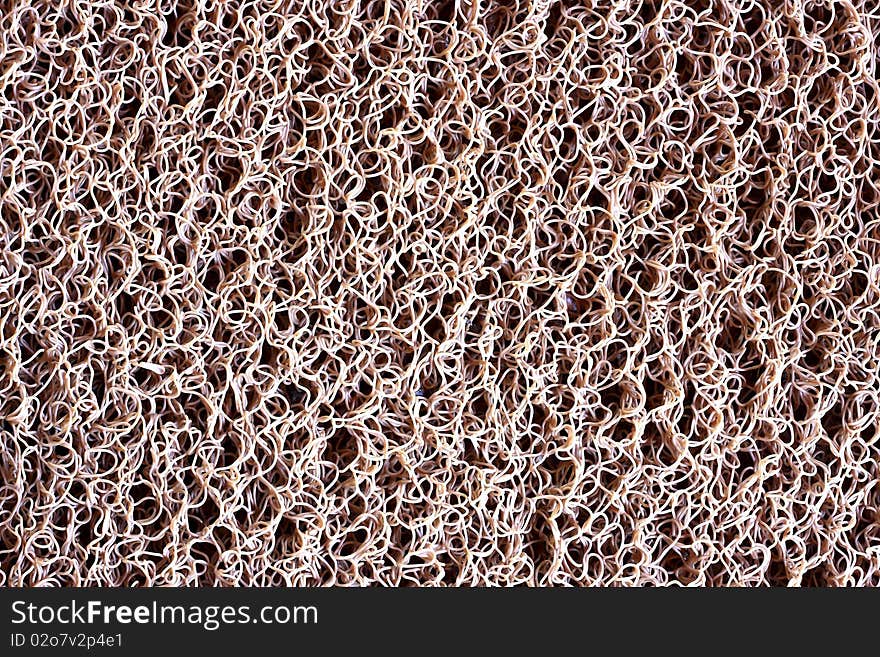 A close-up view of an Brown plastic dust doormat background