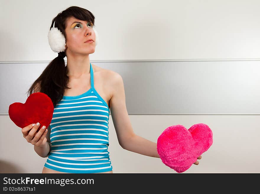 Lovely girl holding two plush hearts. Lovely girl holding two plush hearts.