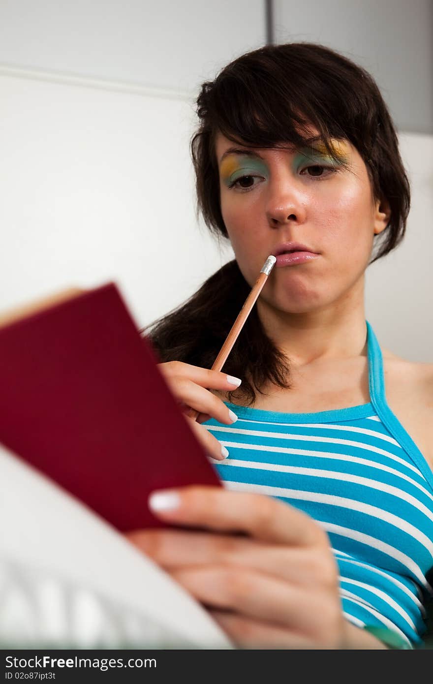 Pretty girl sitting on a sofa and reading a book. Pretty girl sitting on a sofa and reading a book.