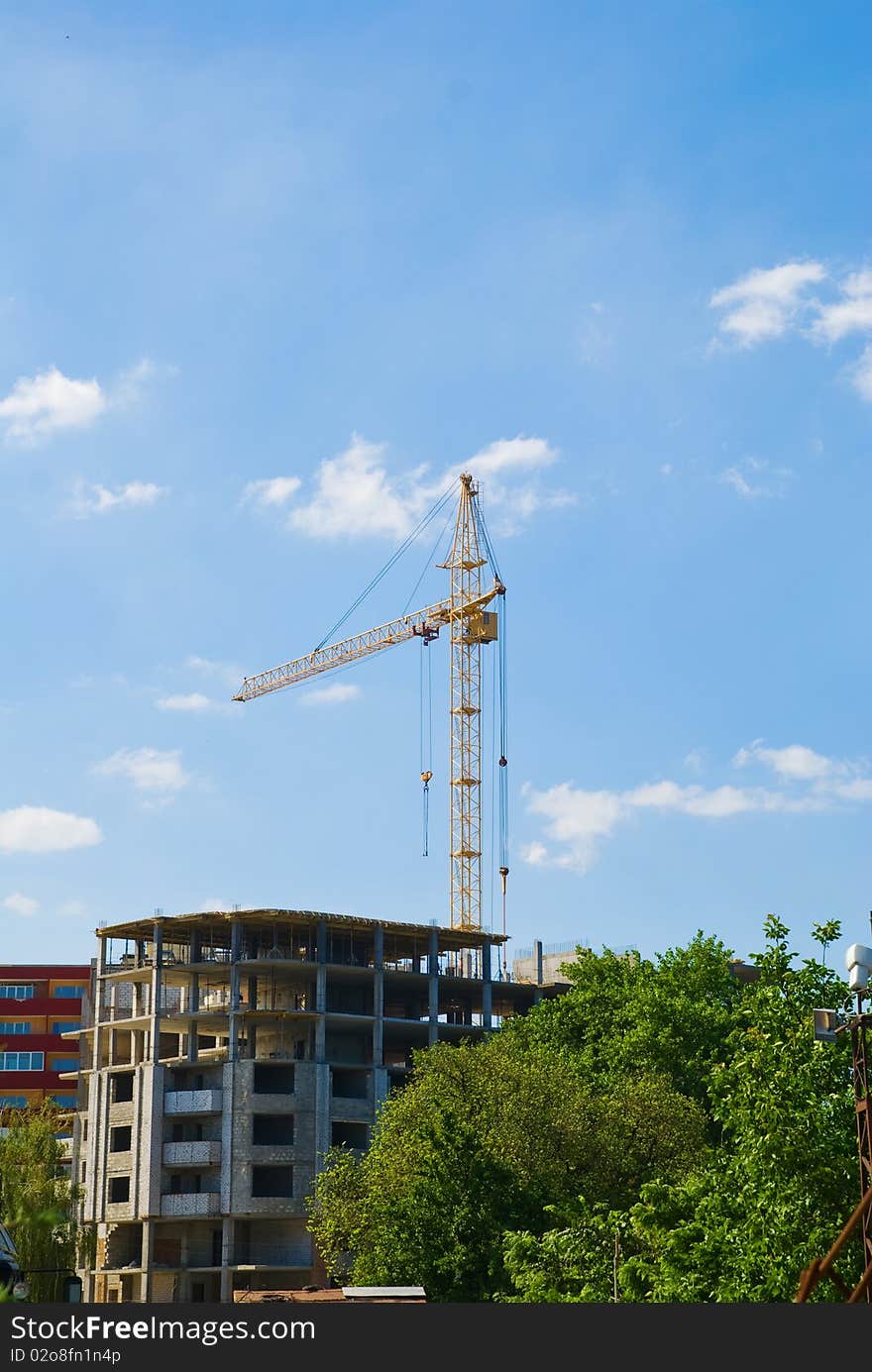 Photos of high-rise construction cranes and unfinished house against the blue sky with clouds.