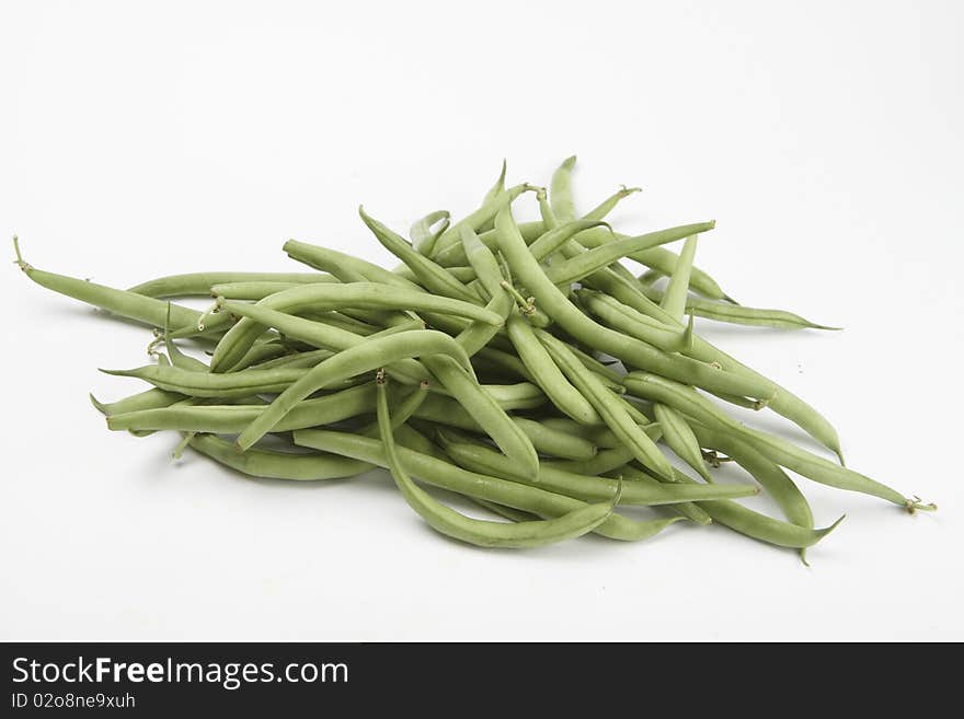 Many raw green beans isolated over white