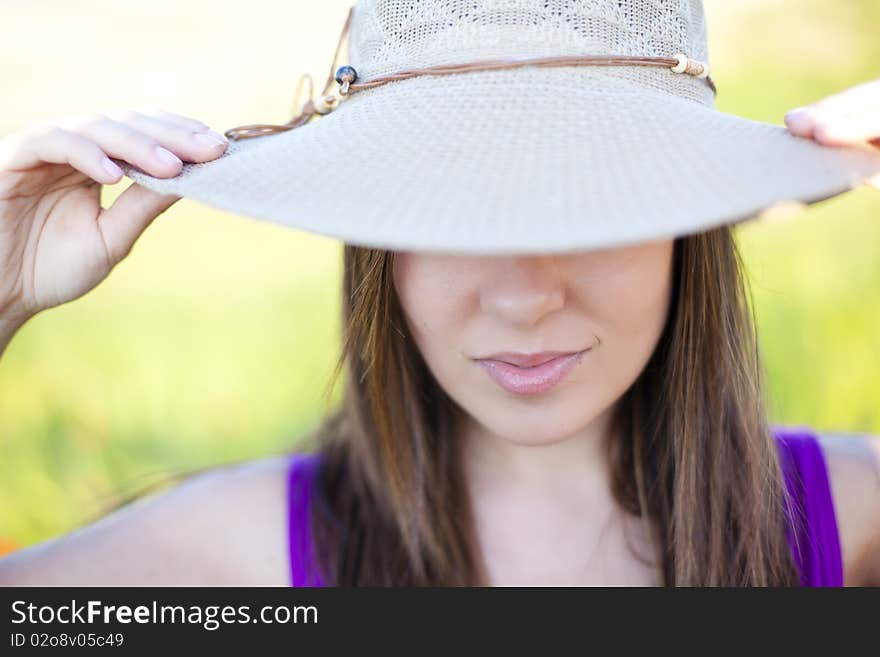 Young girl hidden under her hat. Focus on lips. Young girl hidden under her hat. Focus on lips.