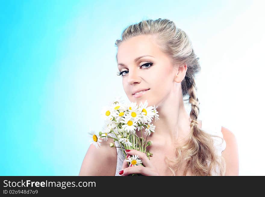 Close-up portrait of a fresh and beautiful woman with camomile.