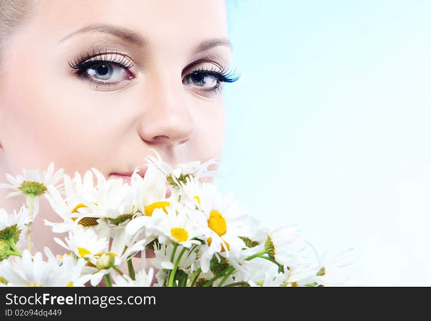 Close-up portrait of a fresh and beautiful woman with camomile.