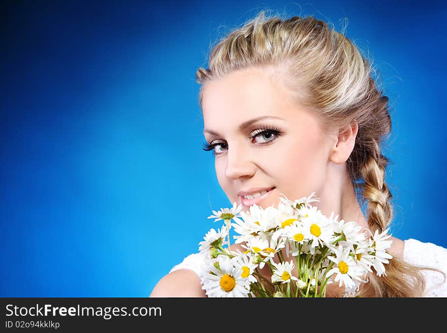 Close-up portrait of a fresh and beautiful woman with camomile.