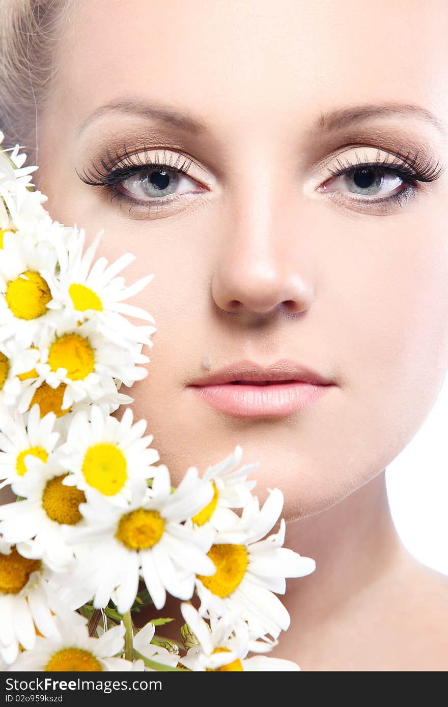 Close-up portrait of a fresh and beautiful woman with camomile.