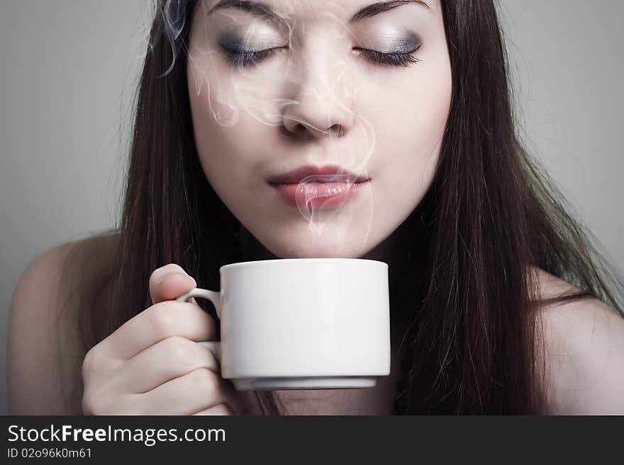 Part of the person of the young brunette holding a cup of coffee. Part of the person of the young brunette holding a cup of coffee.