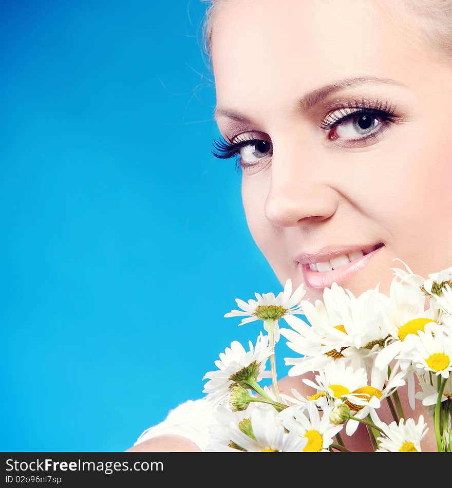 Close-up portrait of a fresh and beautiful woman with camomile.