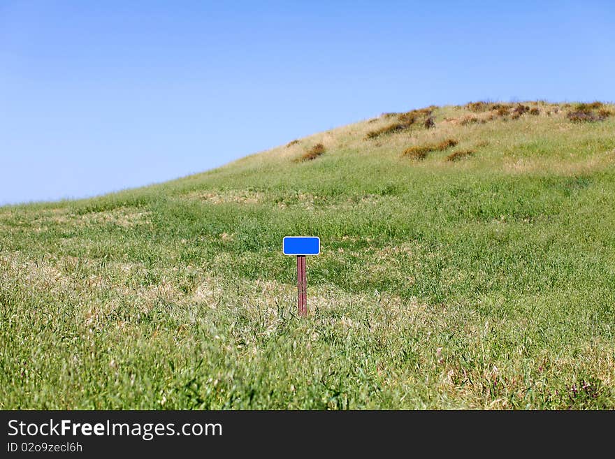 Blank sign on a grassy hill