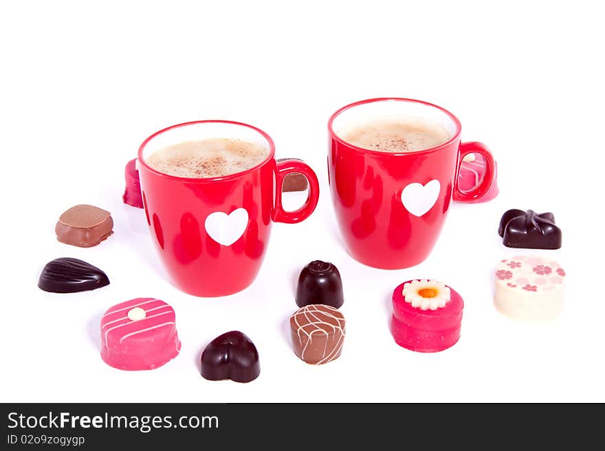 Two lovely cups with coffee and chocolate candy isolated over white