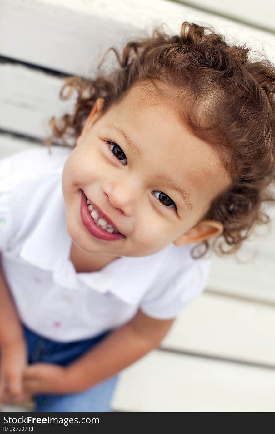 Portrait of a cute little girl on bench