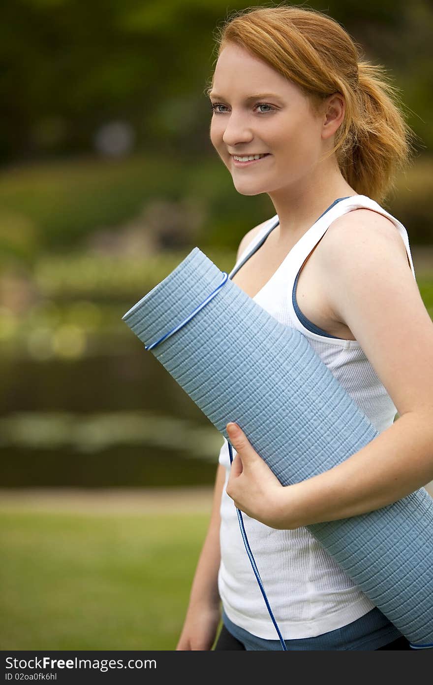 Young woman outside with yoga mat. Young woman outside with yoga mat