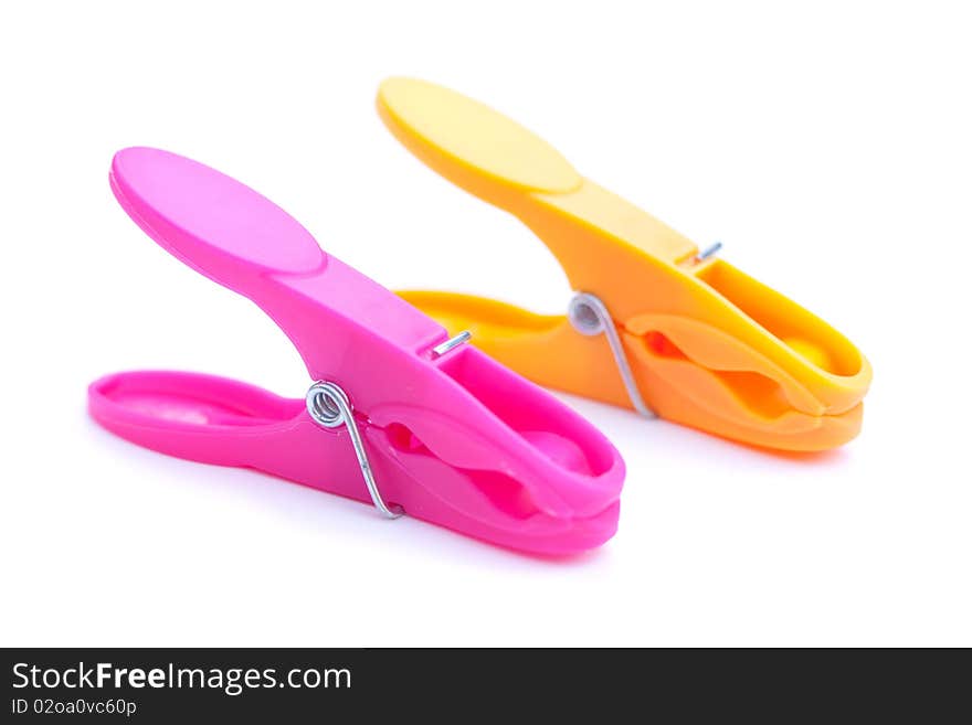 An orange and a pink clothespin isolated over white. An orange and a pink clothespin isolated over white