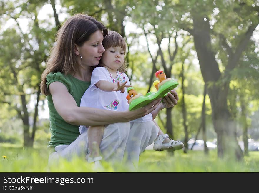 Young mother and daughter playing in park