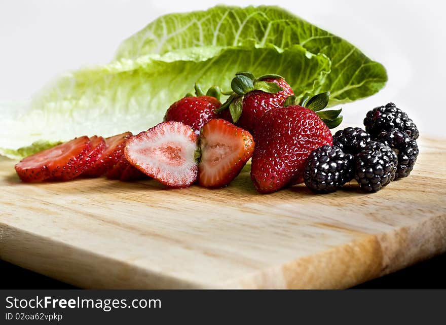 Fresh berries and lettuce on a cutboard. Fresh berries and lettuce on a cutboard