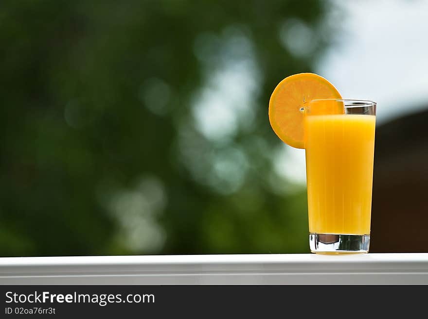 A glass of orange juice with a slice of orange. A glass of orange juice with a slice of orange