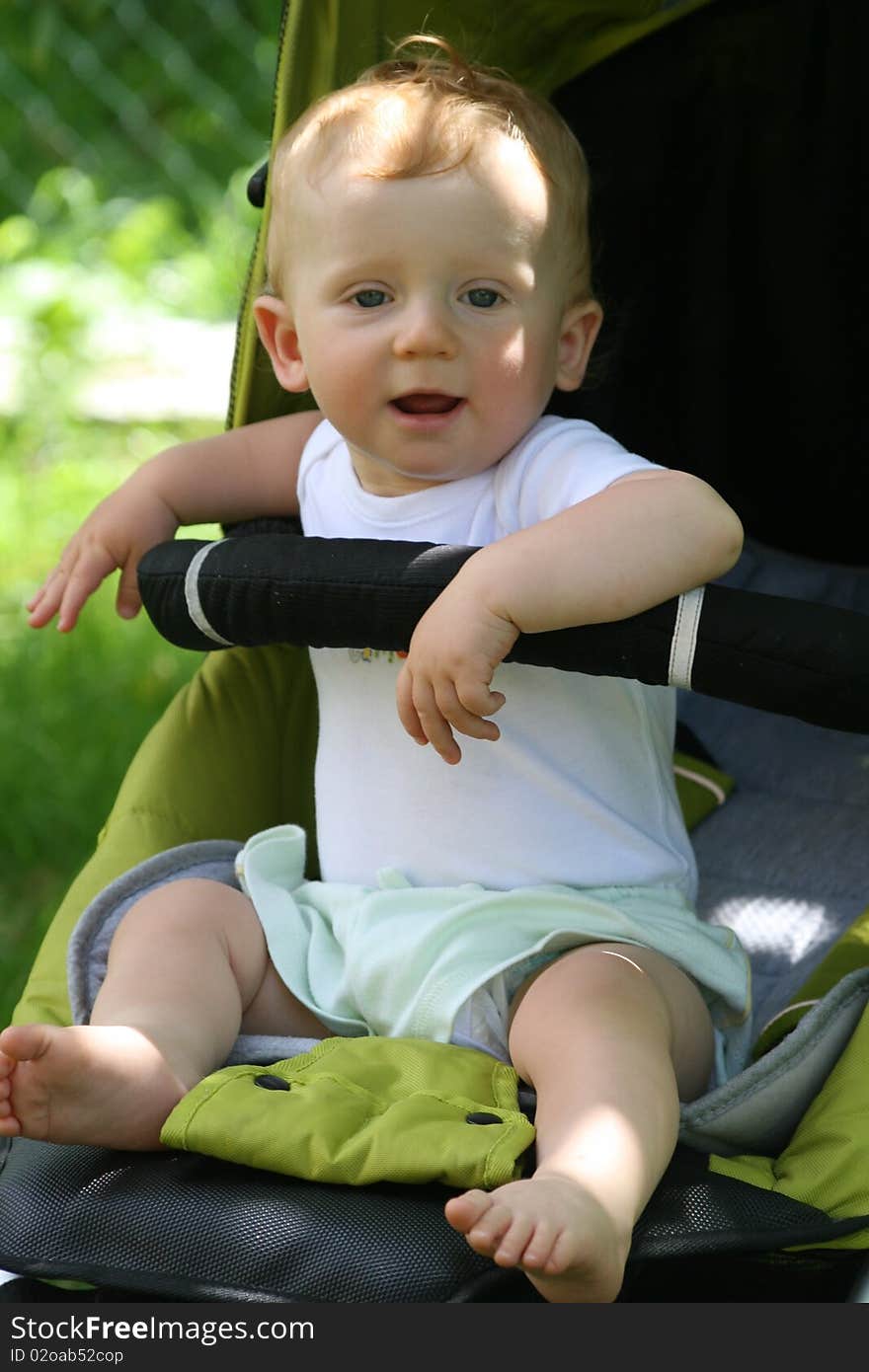 Happy boy in the buggy gives back smile. Happy boy in the buggy gives back smile