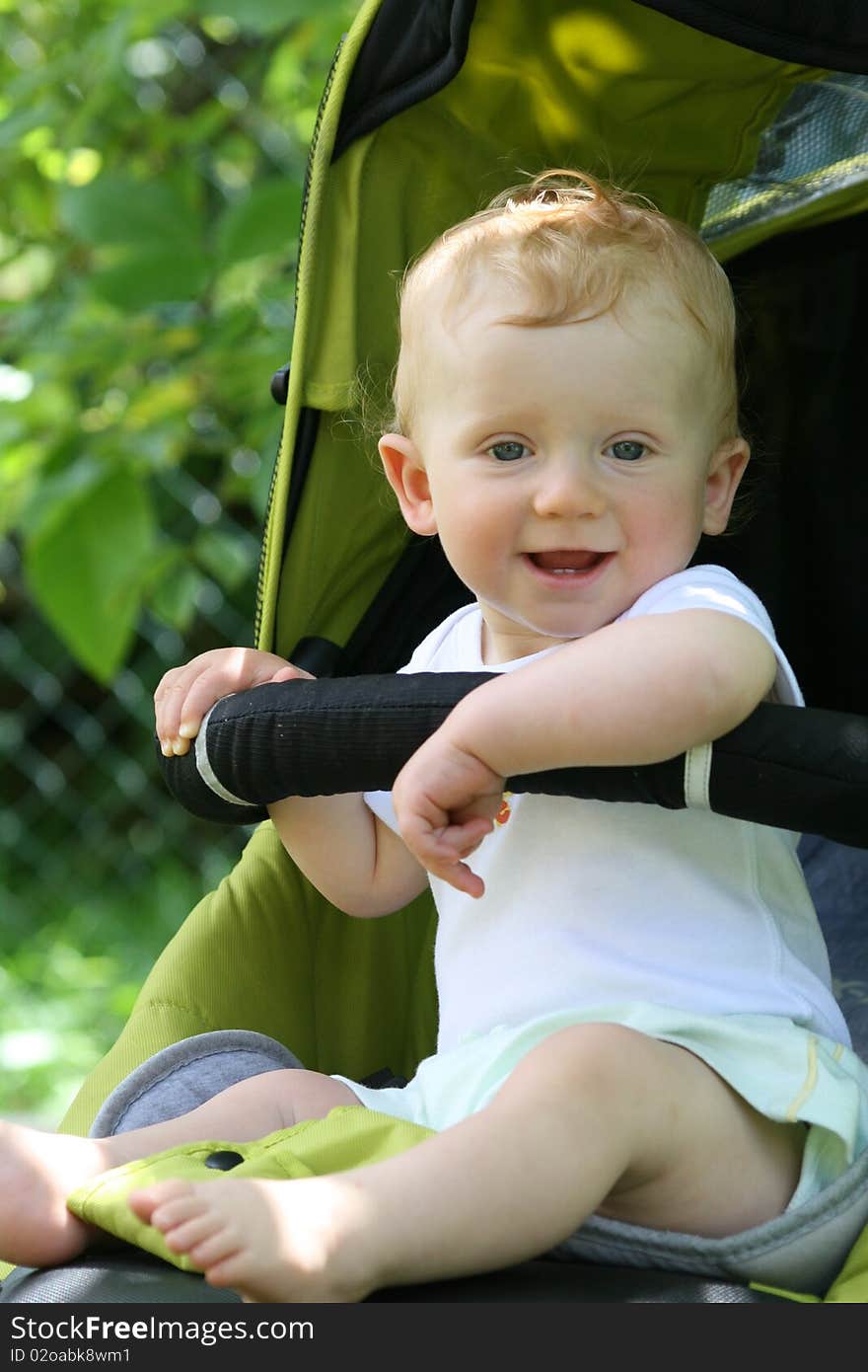 Happy boy in the buggy gives back smile. Happy boy in the buggy gives back smile