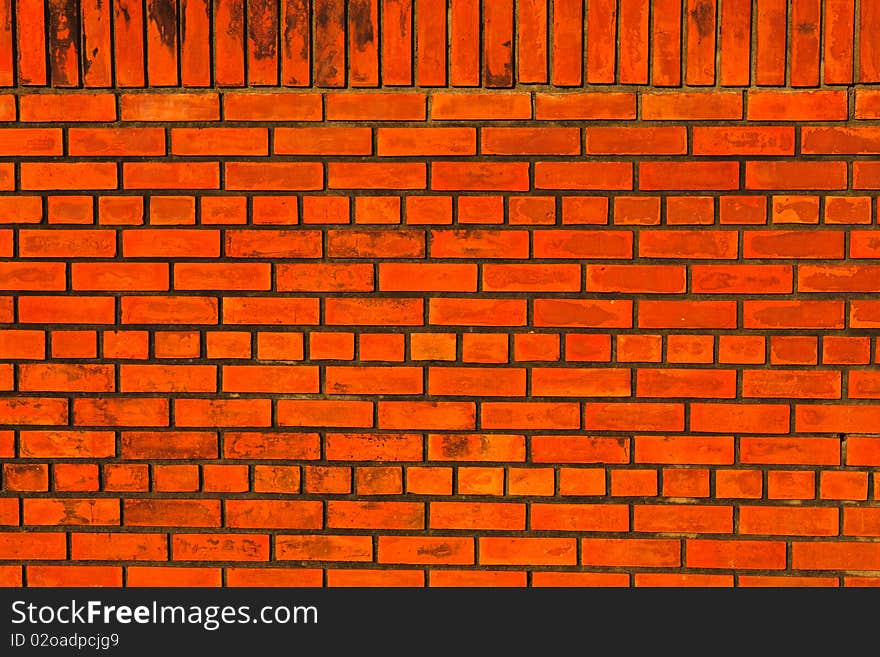 New orange brick wall with vertical and horizontal pattern.