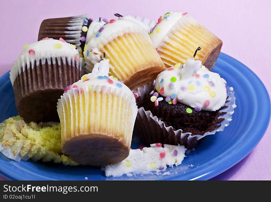 Plate of leftover cupcakes from a party over a pink background. Plate of leftover cupcakes from a party over a pink background