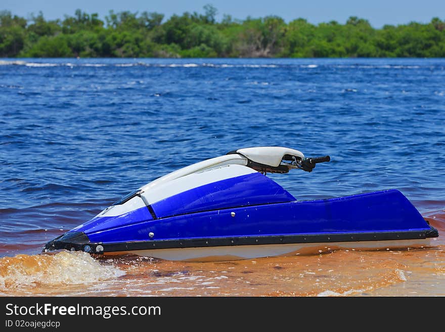 Blue Wave Runner in the water with blue ocean and green mangroves in the background