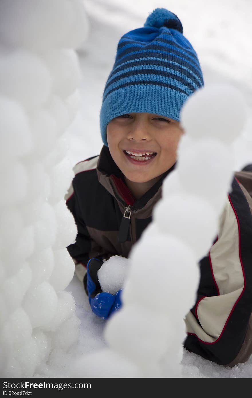 Young Boy Behind Snowball Wall