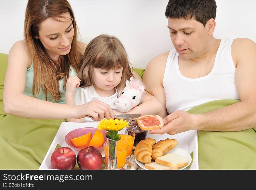 Happy young family at home relaxing in bed. Happy young family at home relaxing in bed