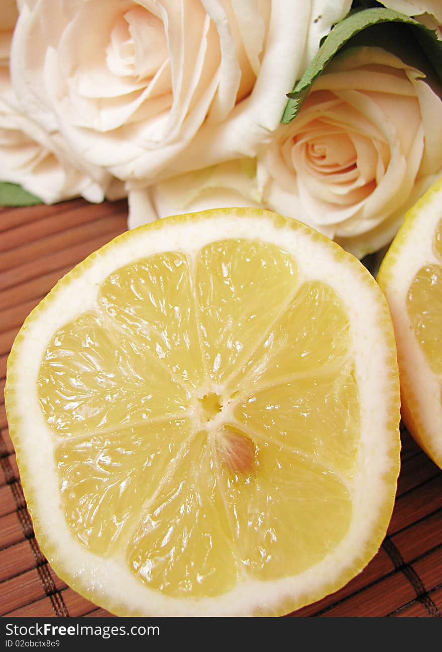 Fresh lemon and creamy roses isolated on wooden background