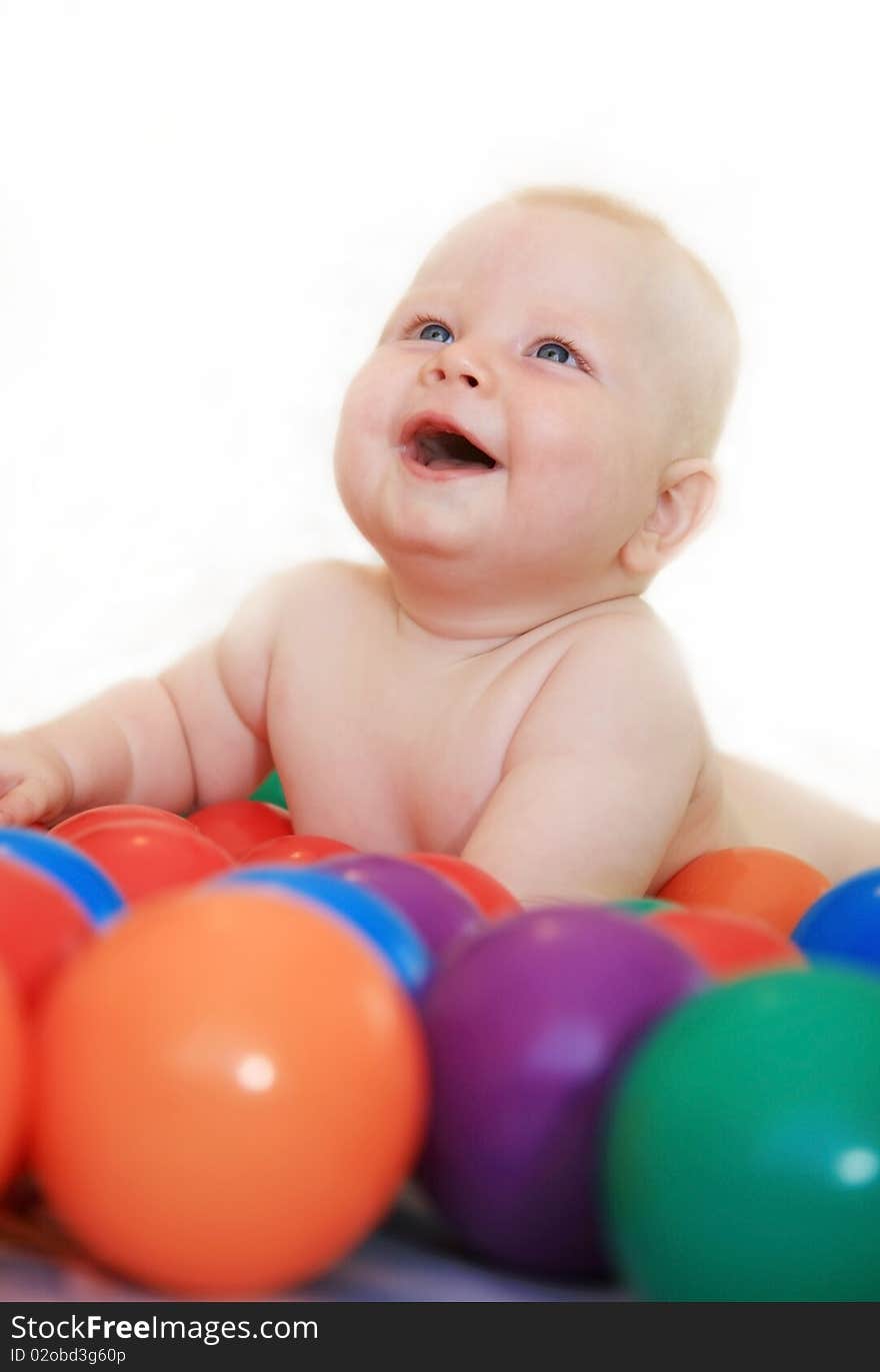 Beautiful white baby naked played with a little colored balls and smiles happily. Beautiful white baby naked played with a little colored balls and smiles happily