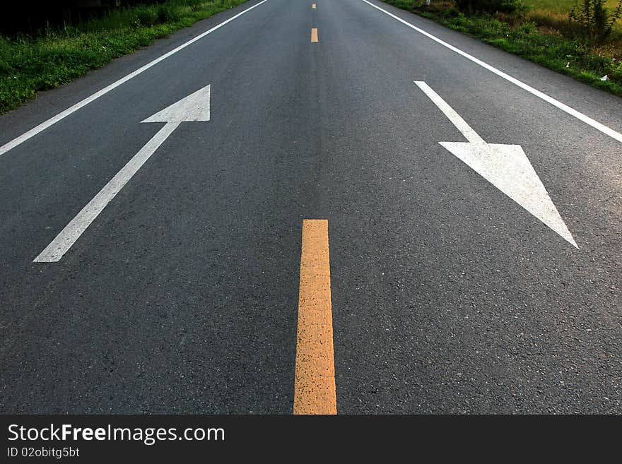 White arrow direction on road. White arrow direction on road