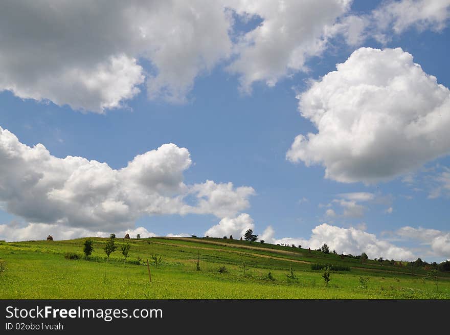 Summer hill under clouds.