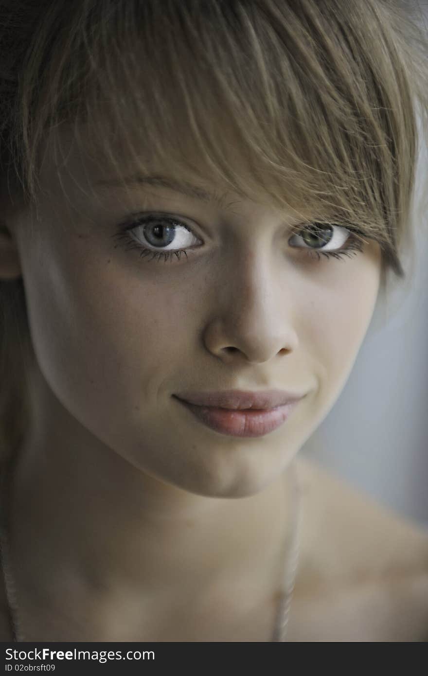 Portrait of the beautiful girl-teenager with blond hair and big blue eyes