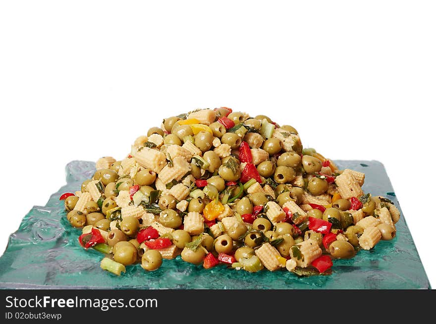 The dish with a salad of pickled corn and olives isolated on a white background. The dish with a salad of pickled corn and olives isolated on a white background.