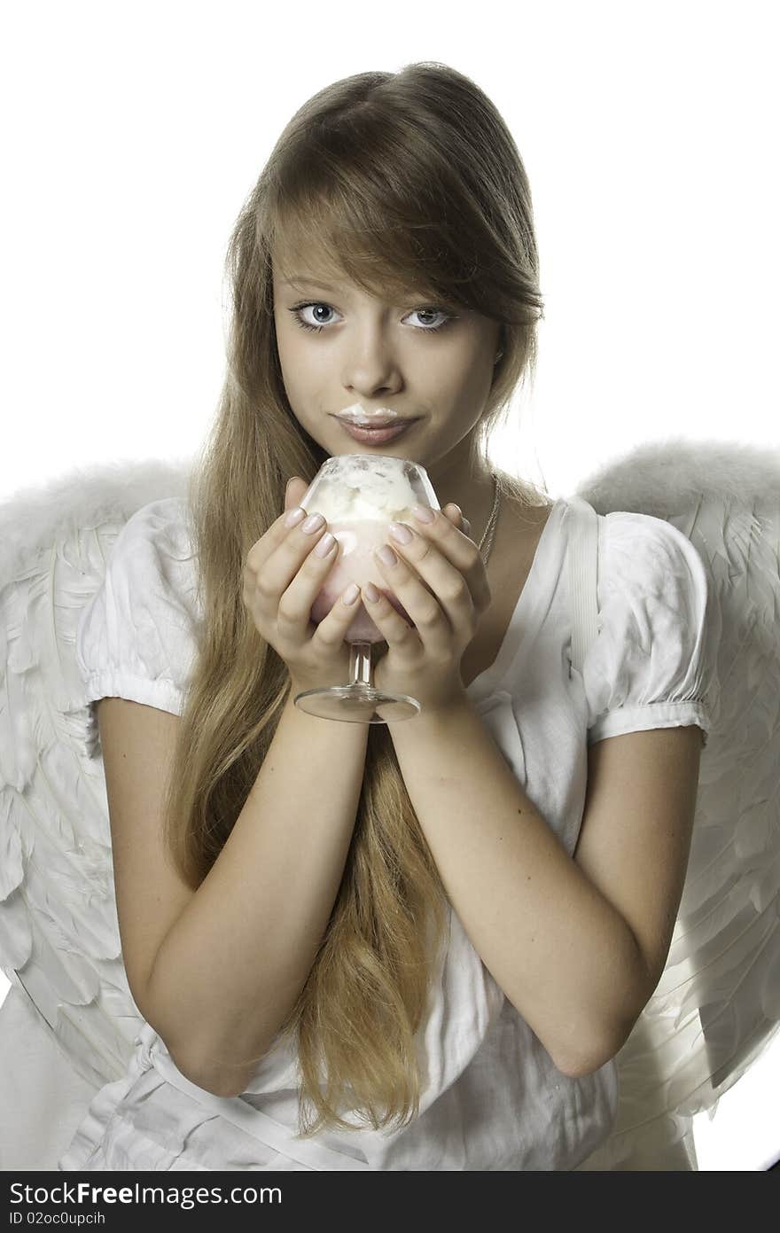 The beautiful girl in a white dress and wings  with  dessert in hands. The beautiful girl in a white dress and wings  with  dessert in hands