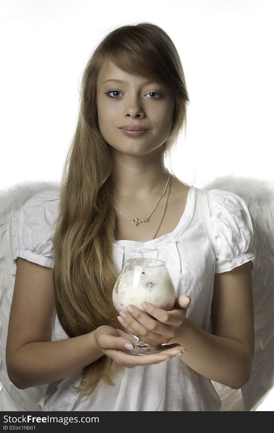 The beautiful girl in a white dress and wings  with  dessert in hands. The beautiful girl in a white dress and wings  with  dessert in hands