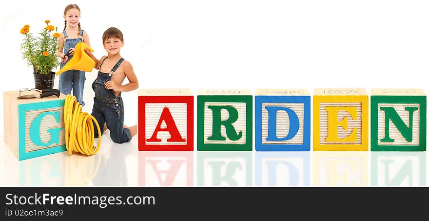 Attractive 5 and 6 year old brother and sister gardening with alphabet blocks. Attractive 5 and 6 year old brother and sister gardening with alphabet blocks.