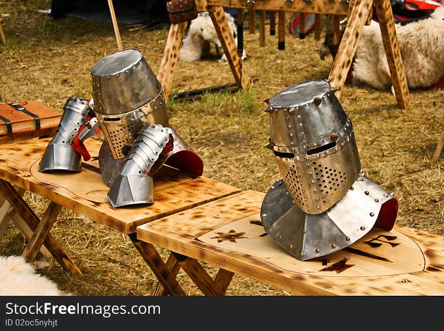 Detail of two medieval helmets arranget on a knight camp