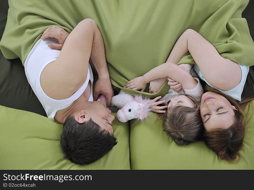 Happy young family at home relaxing in bed. Happy young family at home relaxing in bed