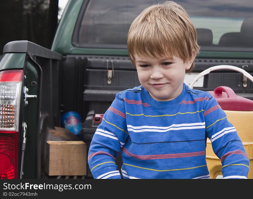 Young boy sitting on a Pickup Bed