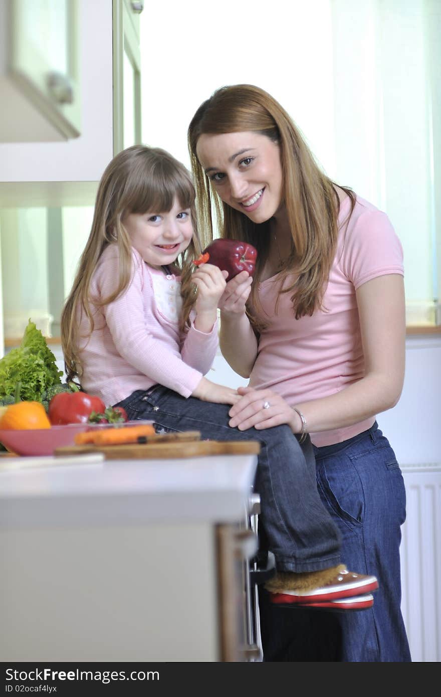 Happy young family have lunch time with fresh fruits and vegetable food in bright kitchen. Happy young family have lunch time with fresh fruits and vegetable food in bright kitchen