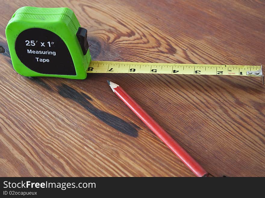 Measuring Tape and Pencil on a wooden table. Preparing to measure to biuld.