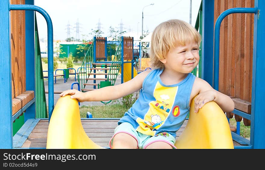 Cute boy sitting on slide. Cute boy sitting on slide