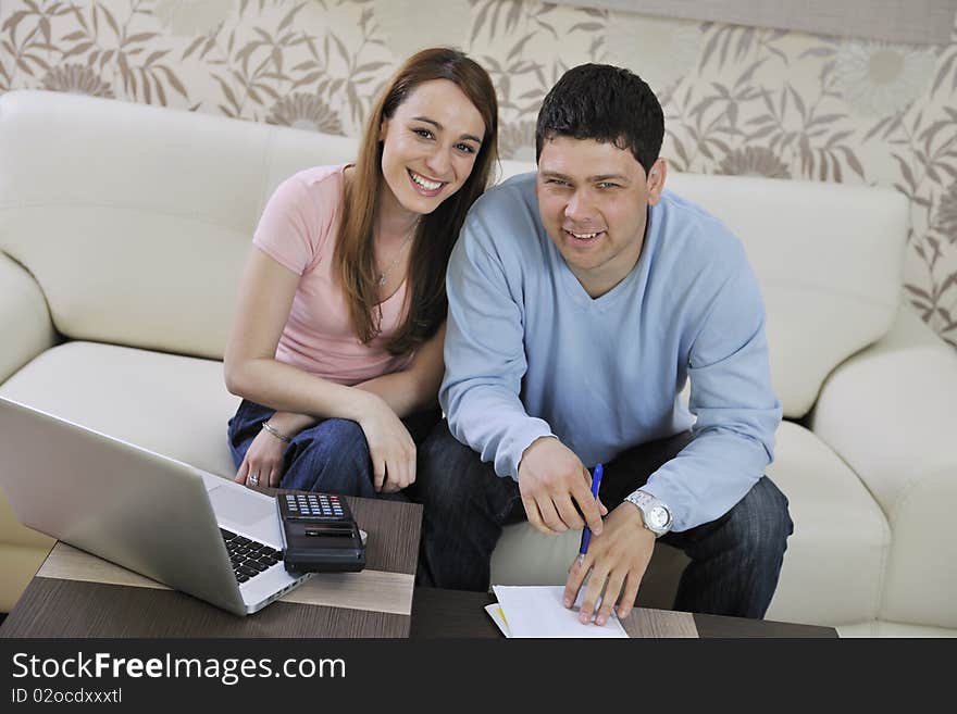 Young couple at home with  modern livingroom indoor working on laptop on house finance and planing. Young couple at home with  modern livingroom indoor working on laptop on house finance and planing