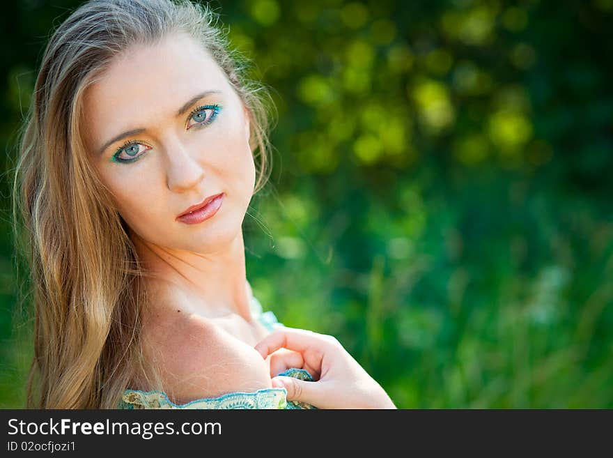 Beautiful woman among green leaves in the forest